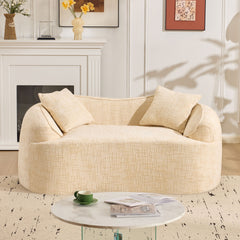 Beige curved two - person compress sofa. It has armrests on both sides, comes with two pillows, is suitable for small - sized apartments, and can be placed in the living room or bedroom.