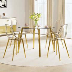 Table and chair set.Modern circular transparent tempered glass table, tempered glass tabletop, golden metal table legs.A Set of 4 Transparent Plastic Chairs with gold legs.