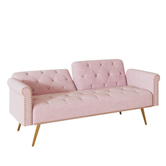 A 69.7-inch-long sofa bed covered in pink velvet fabric, featuring nail head trim and accompanied by a matching throw pillow