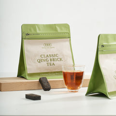 Green tea packaging with a glass of tea on a white background