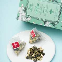 Tea bags and loose tea on a white plate with a green tea box in the background.