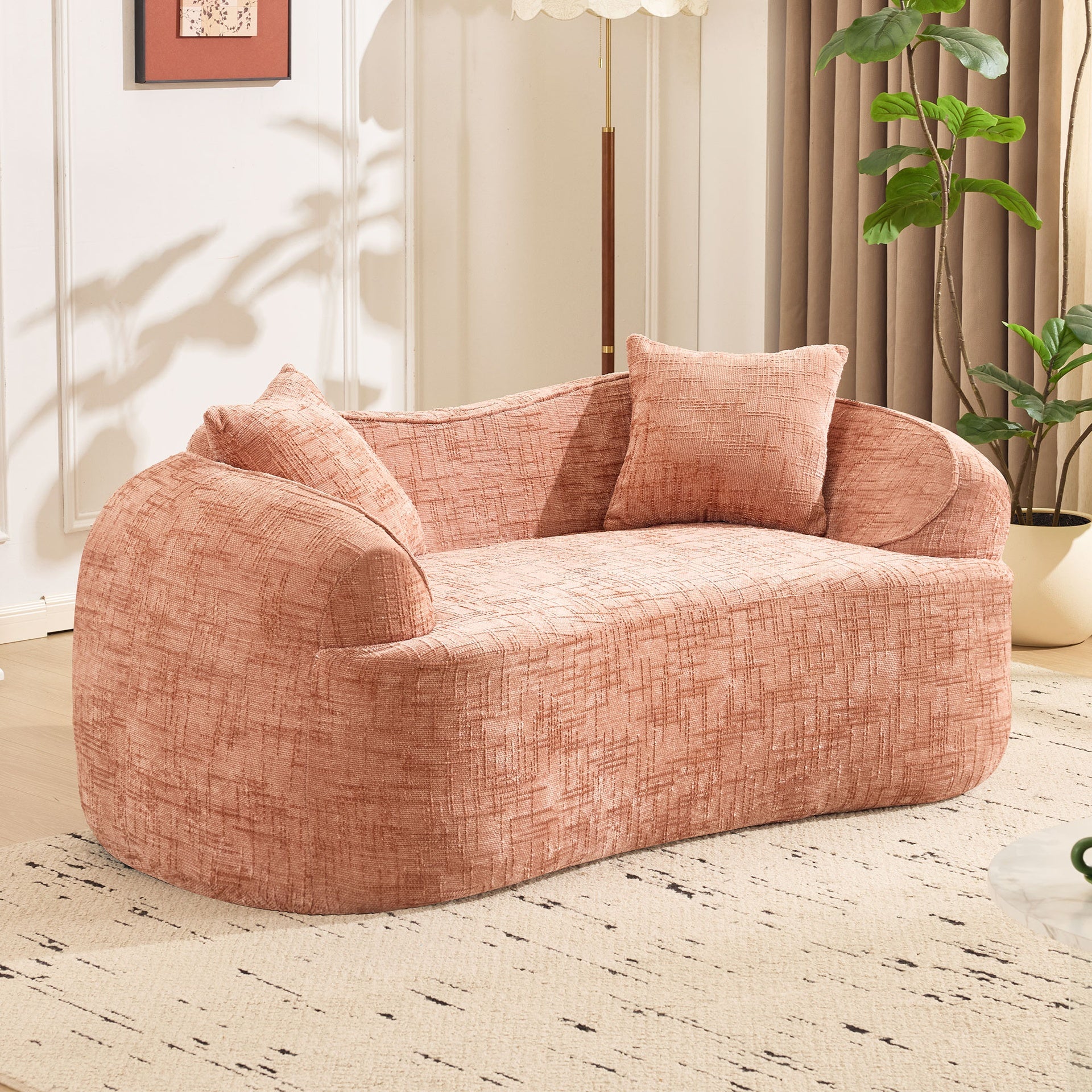 Pink curved two - person compress sofa. It has armrests on both sides, comes with two pillows, is suitable for small - sized apartments, and can be placed in the living room or bedroom.
