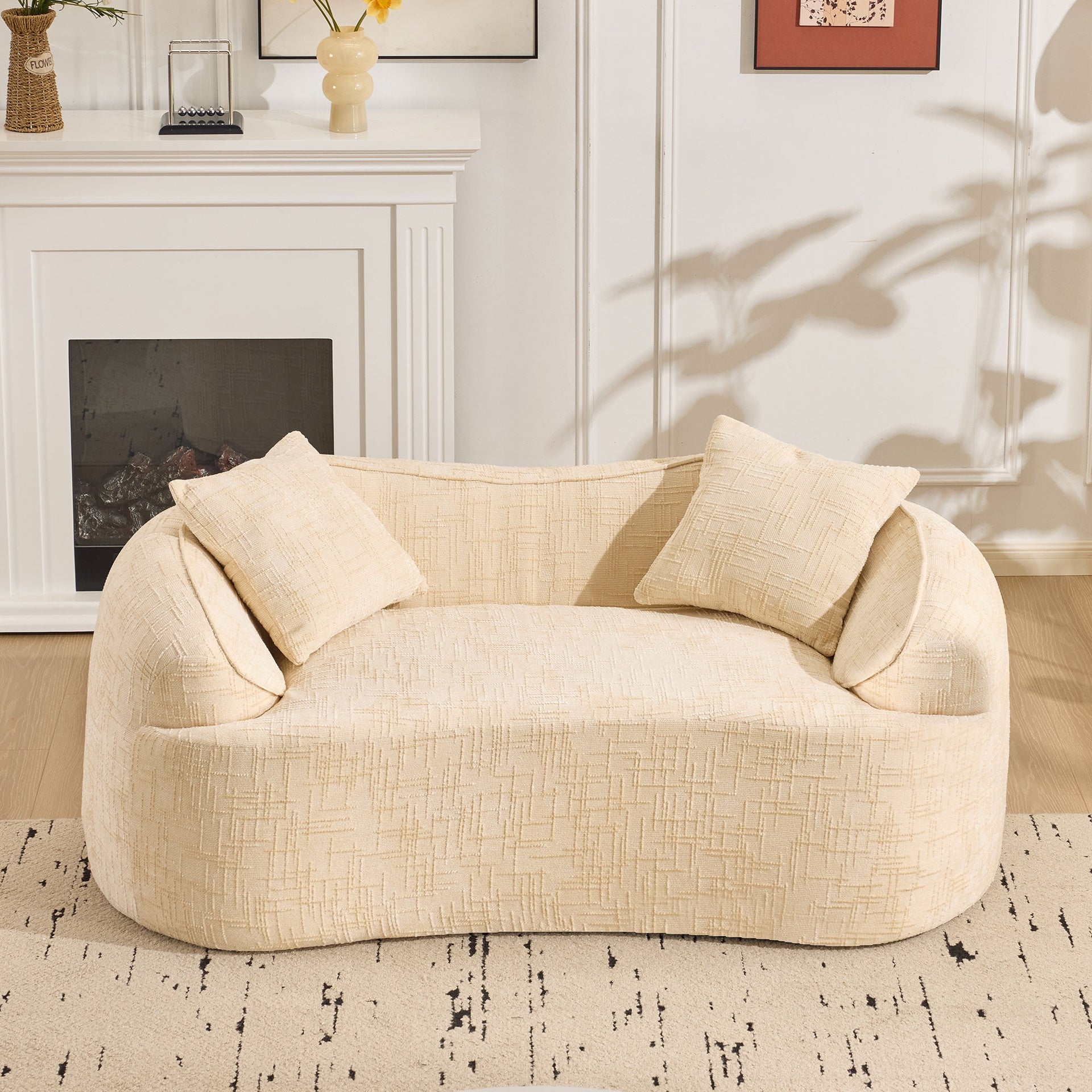 Beige curved two - person compress sofa. It has armrests on both sides, comes with two pillows, is suitable for small - sized apartments, and can be placed in the living room or bedroom.