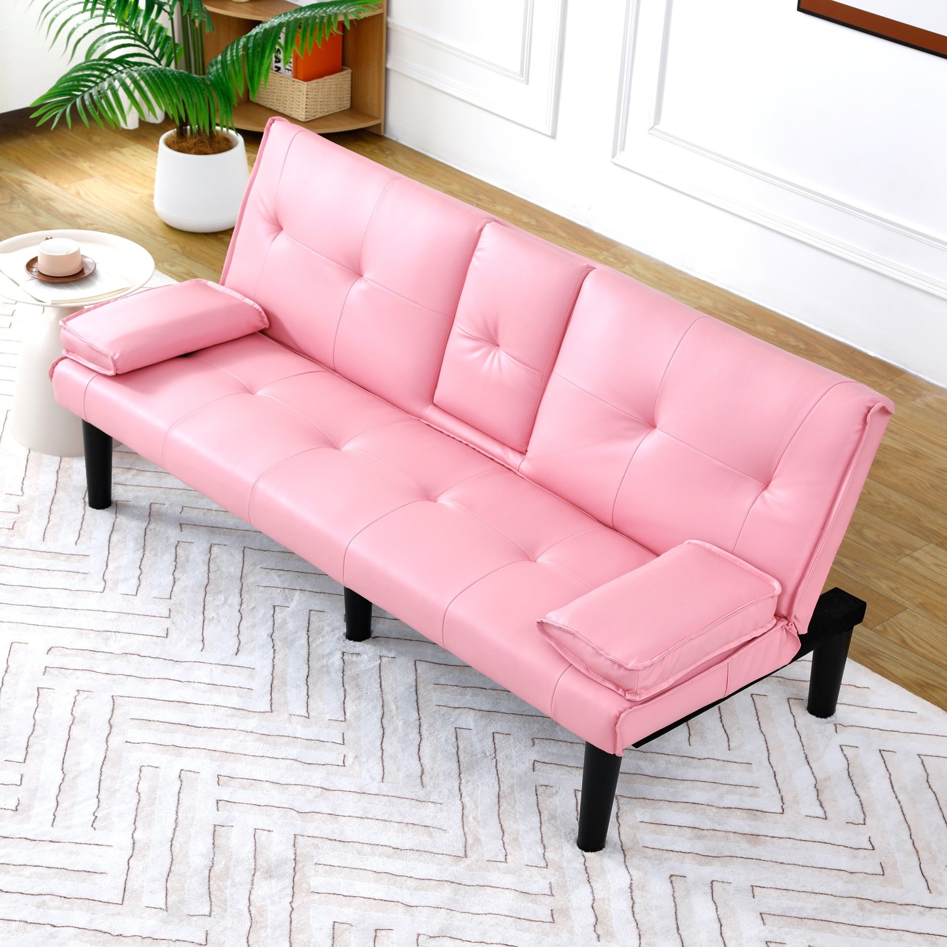 The 67-inch pink PVC multi-functional sofa bed, with a foldable and cup holder design, makes it extremely convenient to turn the living room into a guest room