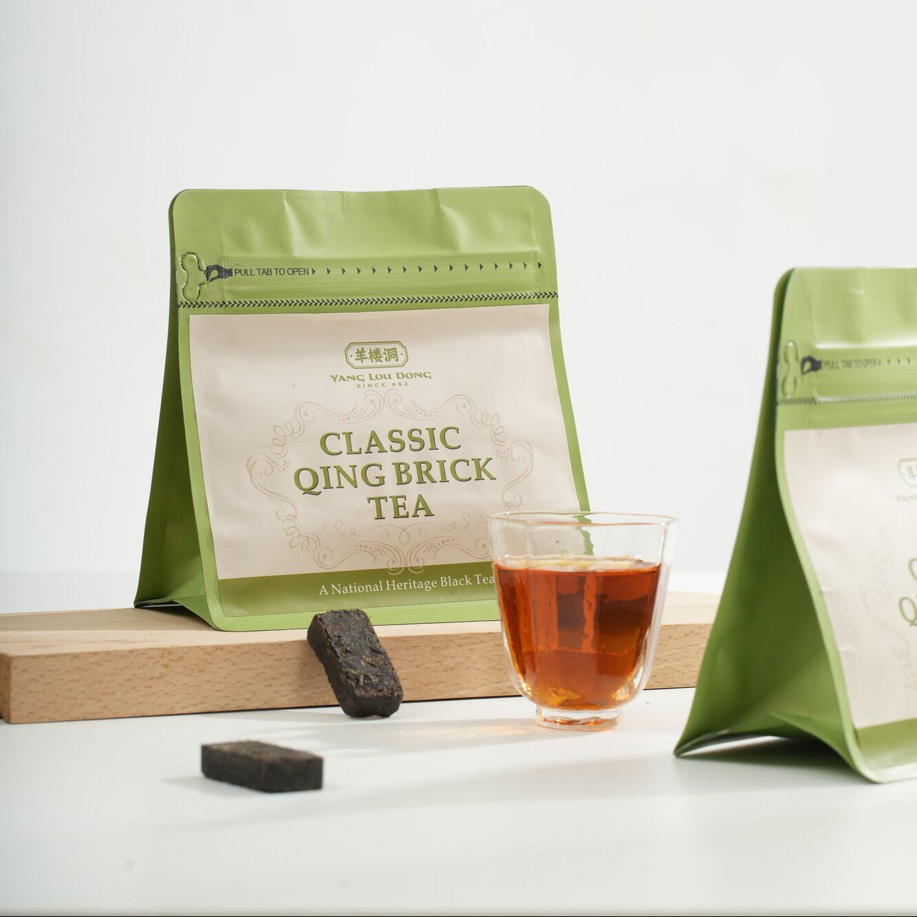 Green tea packaging with a glass of tea on a white background