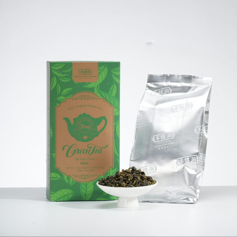 Tea packaging with a green label and a clear container of tea leaves on a white background