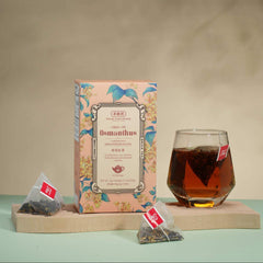 Tea packaging with a glass of tea on a wooden tray against a beige background