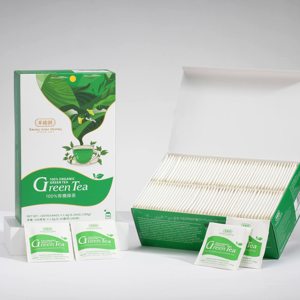Green tea packaging with boxes and bags on a gray background