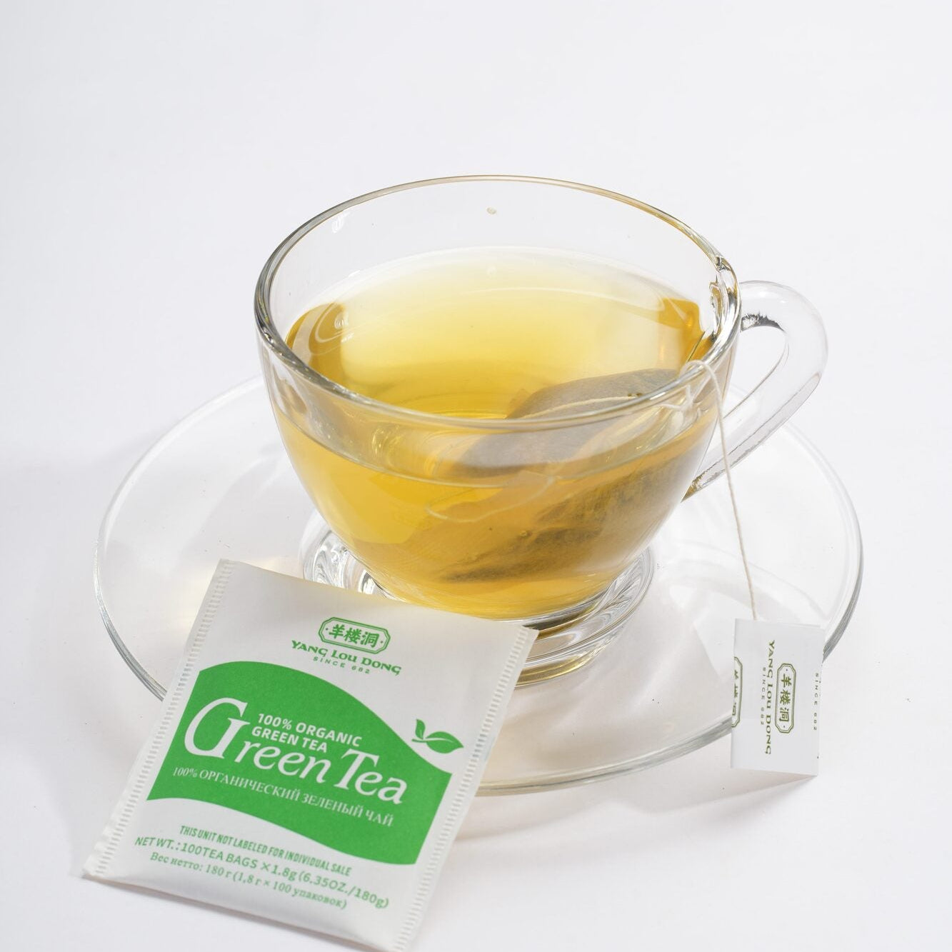 Glass of green tea with a tea bag on a white background
