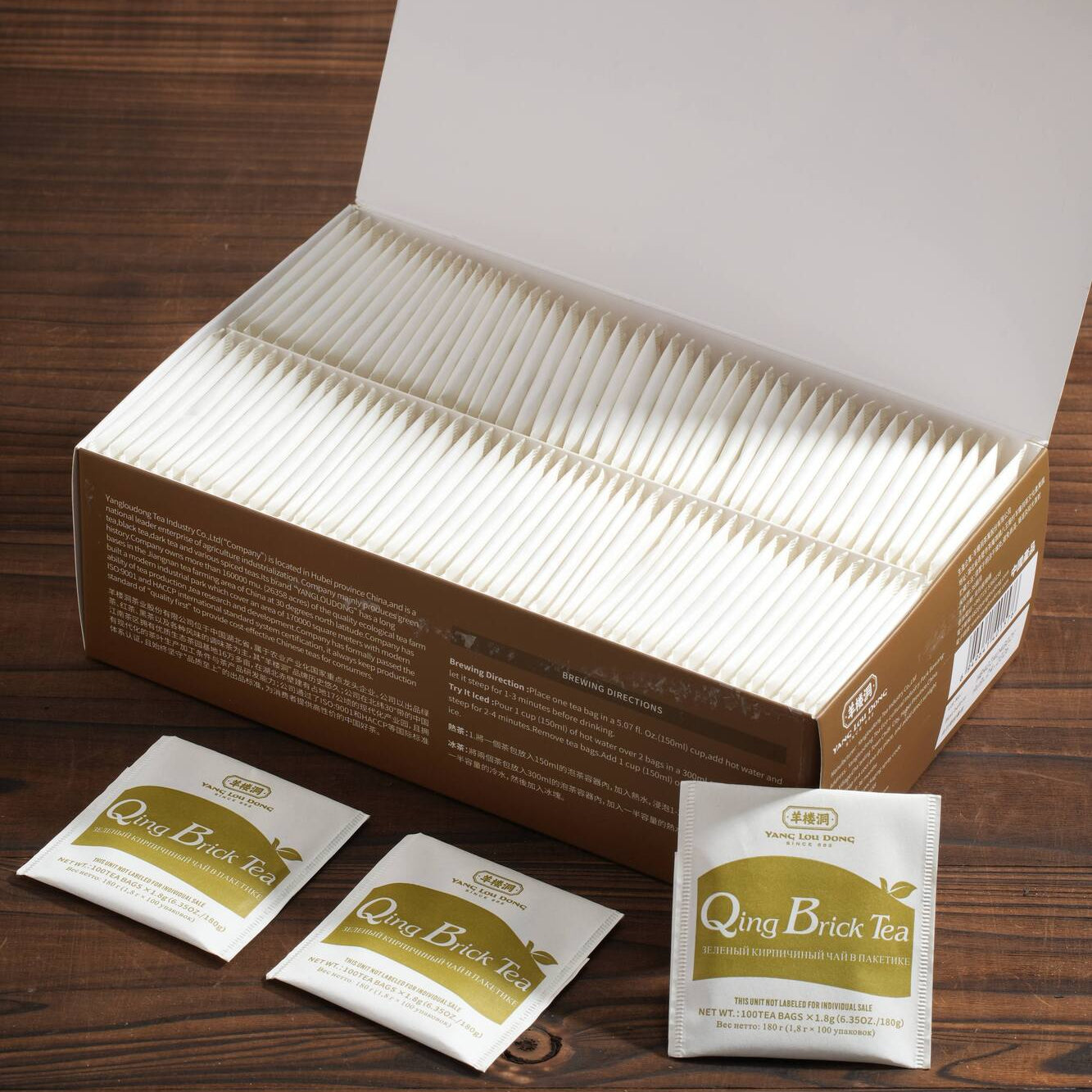 Box of Qing Brick Tea with individual tea bags on a wooden surface